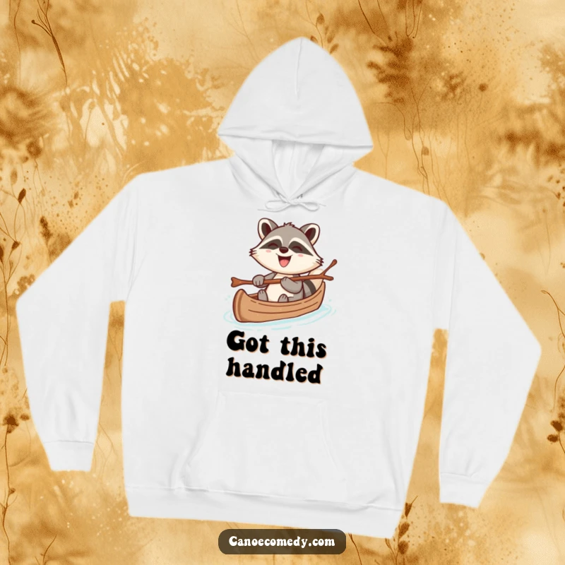 Funny hoodie featuring a cheerful kawaii raccoon steering a canoe with a twig, grinning broadly, perfect for cozy, humorous wear.
