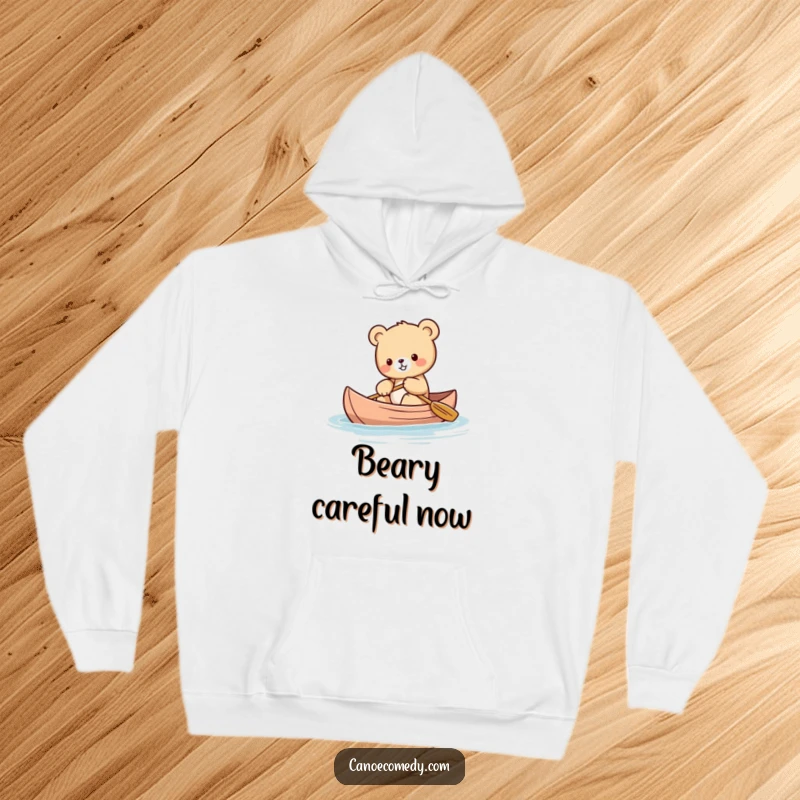 Funny Kawaii bear cub hoodie depicting a cute bear cub attempting to balance itself while paddling a canoe.