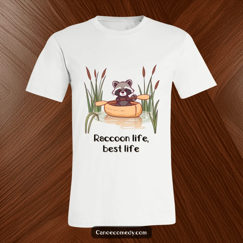 Funny raccoon t-shirt illustration of a raccoon navigating a canoe with precision through a bed of reeds.