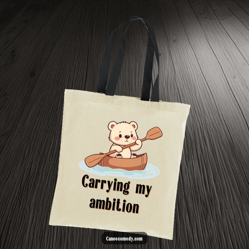 Funny tote bag design with a small, determined bear cub paddling a canoe with all its might.